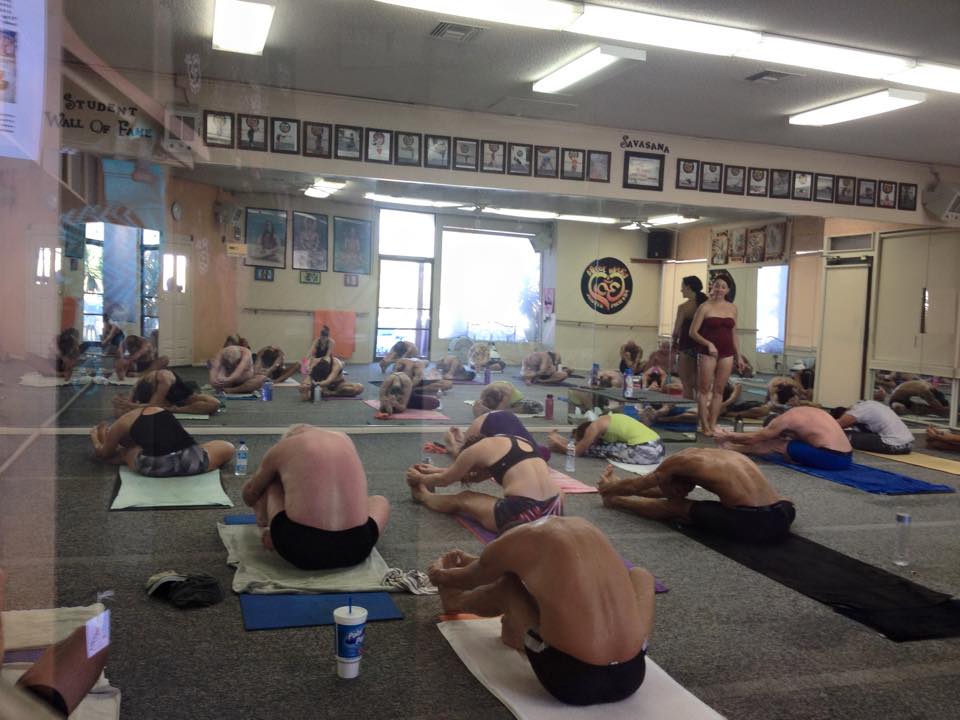 Students in Janushirasana & Paschimotthanasana (Seated Forward Bend Pose) during a Bikram Yoga El Paseo class in Palm Desert.